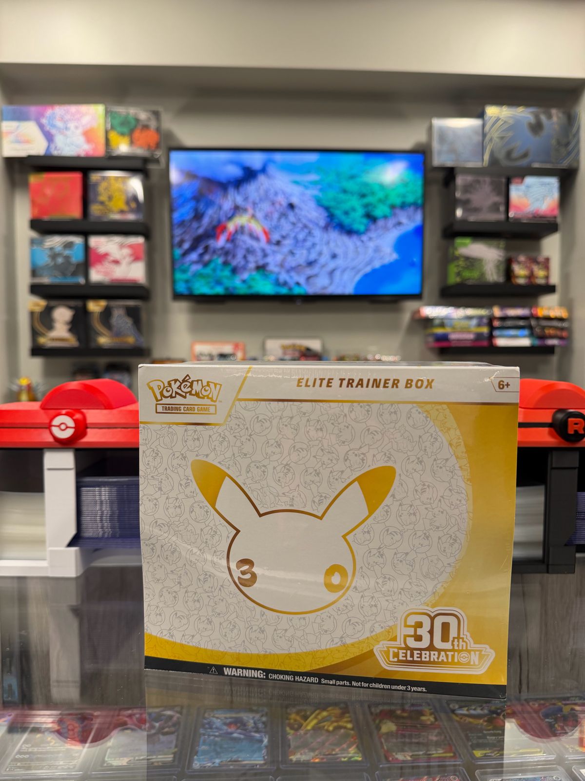 A Pokémon 30th Celebration Elite Trainer Box standing on the shop counter